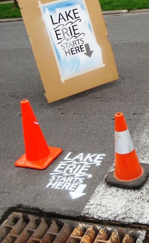 Lake Erie Starts Here spray painted beside sewer grate in road